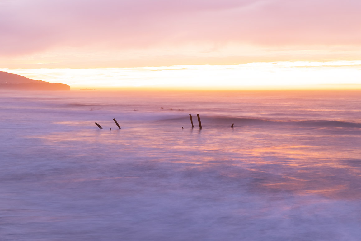 Poles and surfers at dawn